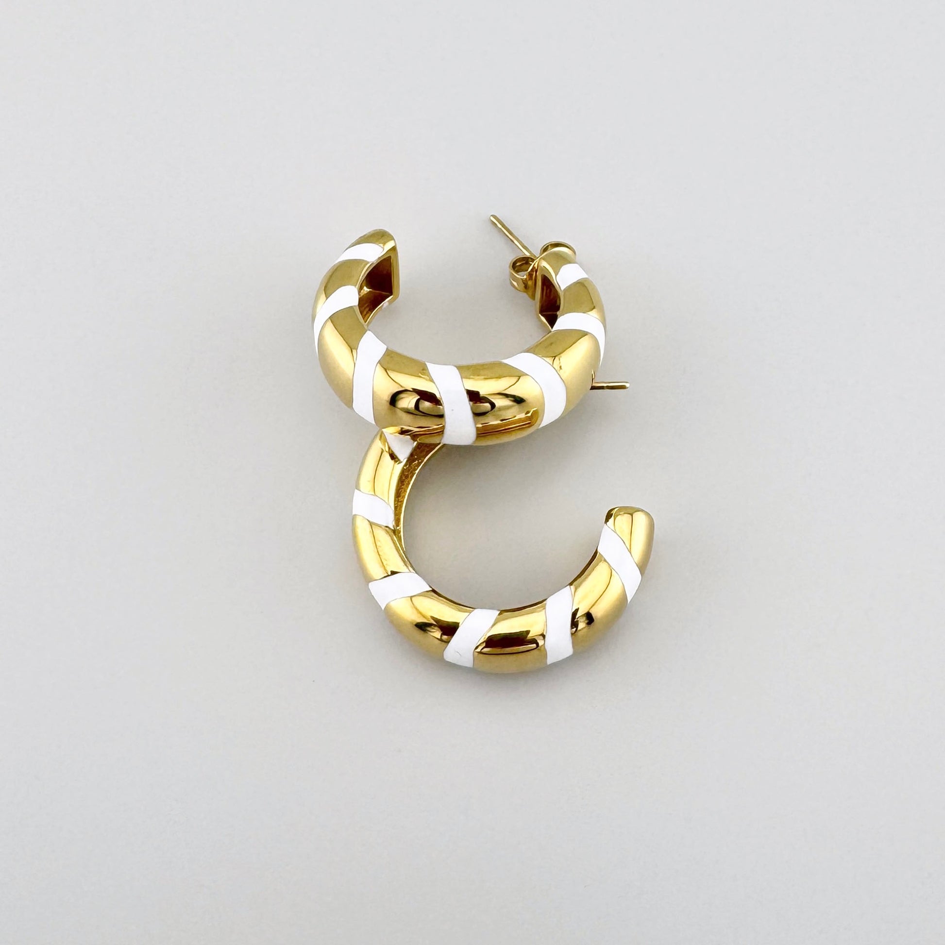 Gold-plated hoop earrings with white enamel stripes, French brand Ikita.