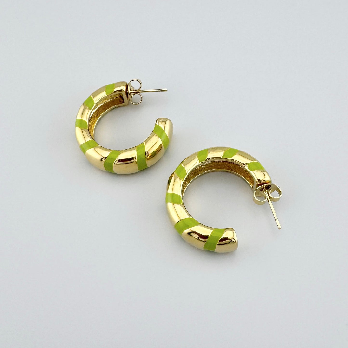 Gold-plated hoop earrings with green enamel stripes, French brand Ikita.