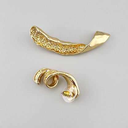 Asymmetrical gold-tone earrings with hammered texture and artistic shape. Brand Cannelle.