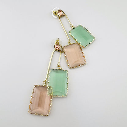 Gold-colored earrings with rectangular, faceted glass elements in pastel shades of green and peach.