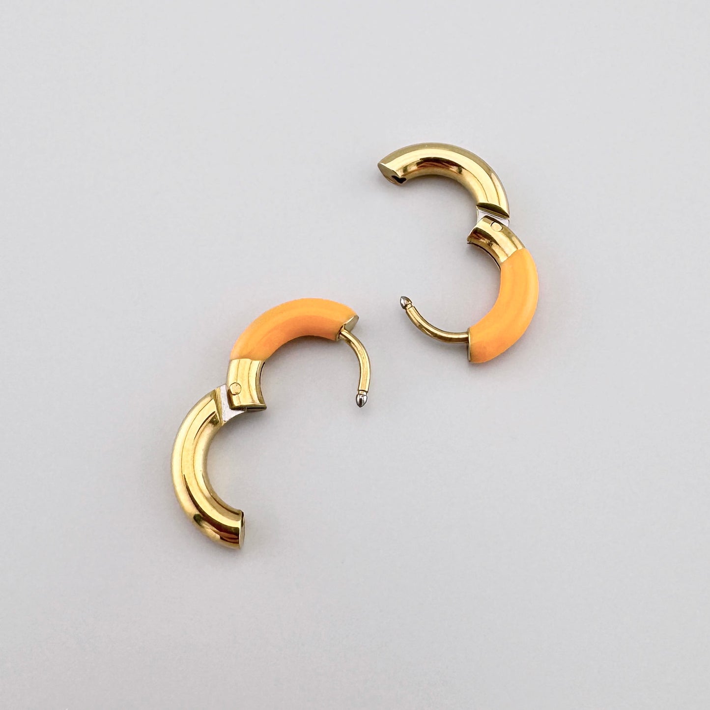 Pendientes de aro dorados con esmalte naranja, marca francesa Ikita.