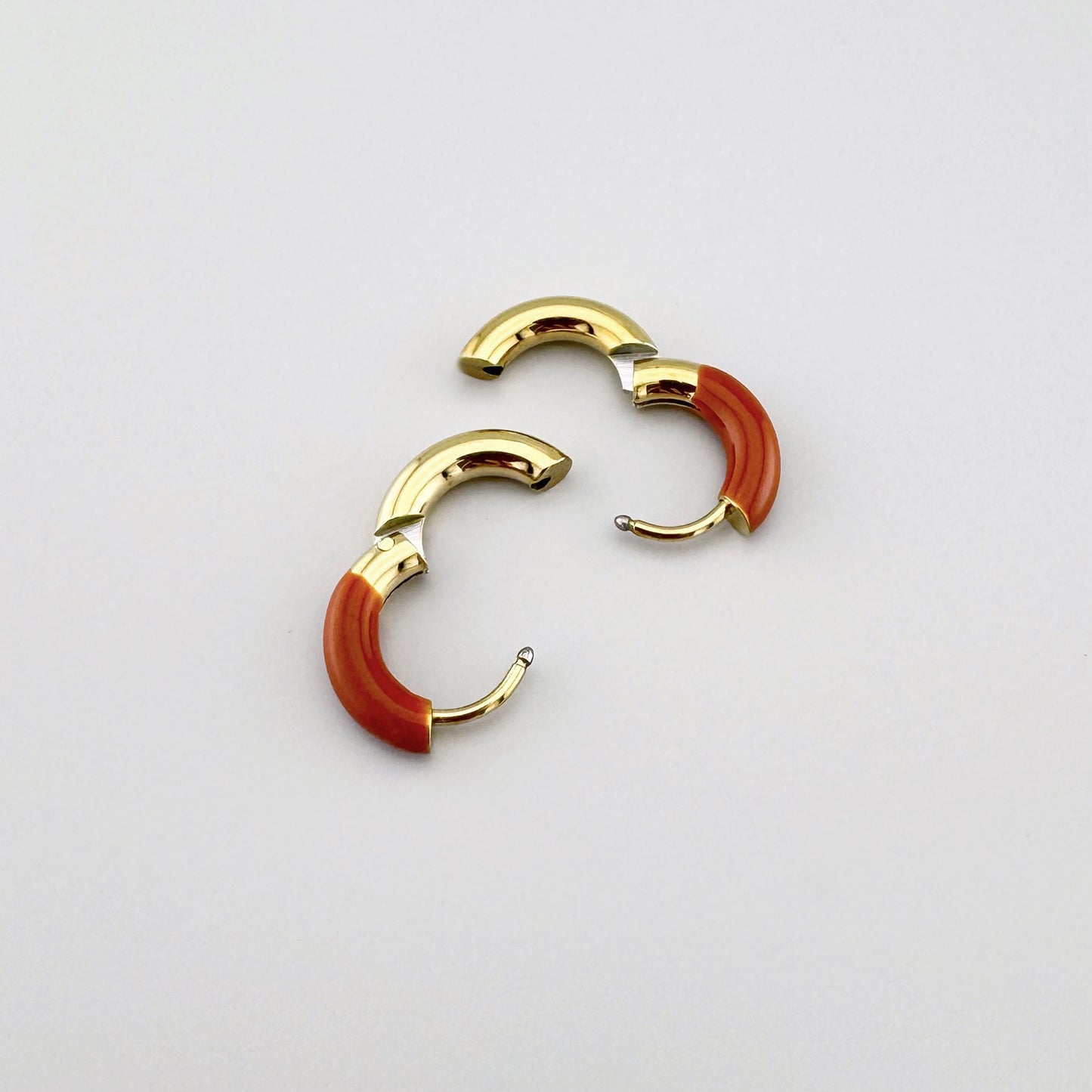 Gold hoop earrings with terracotta enamel, French brand Ikita.