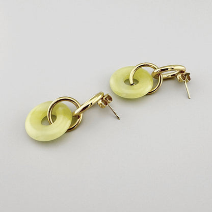 Dangling earrings with gold-plated chain links and a light yellow element, French brand Ikita.