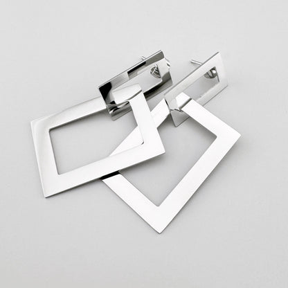 Geometric earrings in silver color made of two rectangular elements, Spanish brand Maravillas.