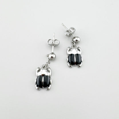 Dangling beetle-shaped earrings with black enamel, French brand Ikita.