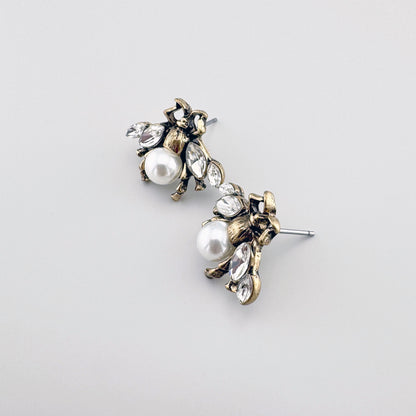 Bee-shaped earrings in antique gold, adorned with a faux pearl and crystals.