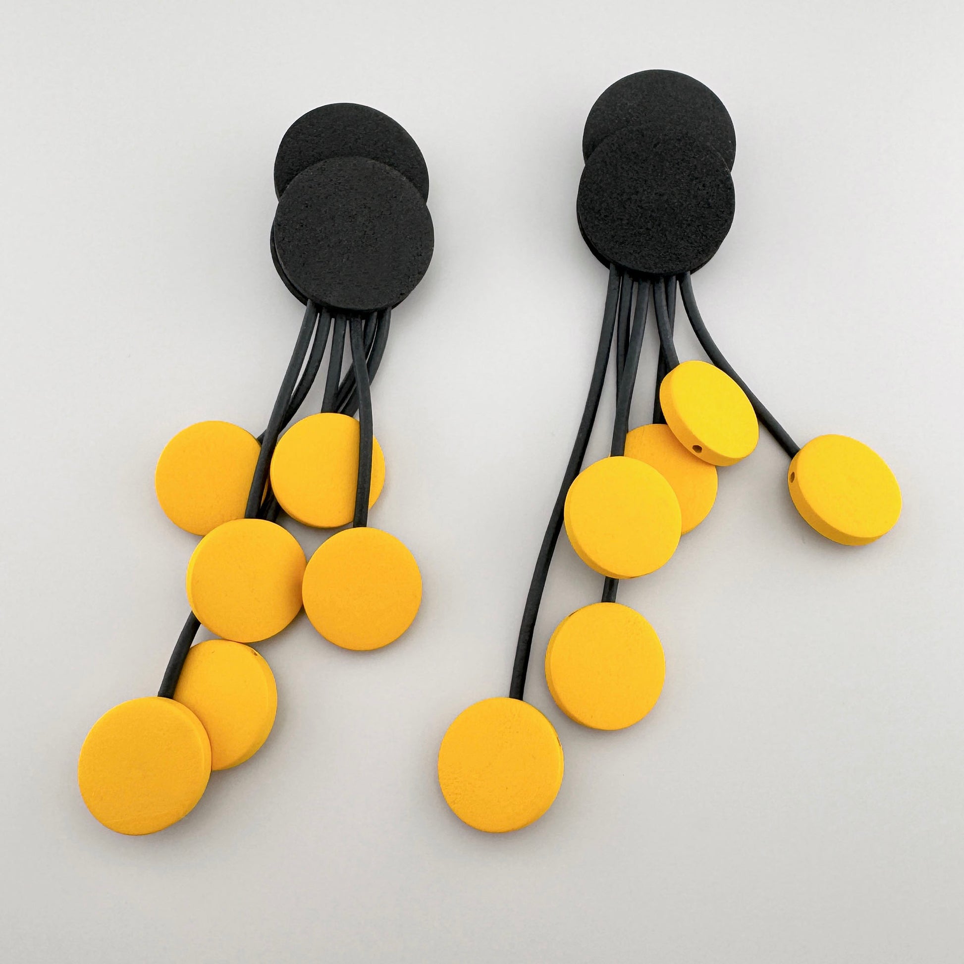 Earrings with black and yellow circles in a modern design.