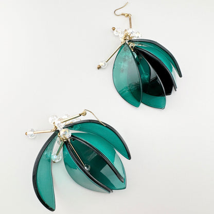 Green leaf-shaped earrings with sparkling crystals.