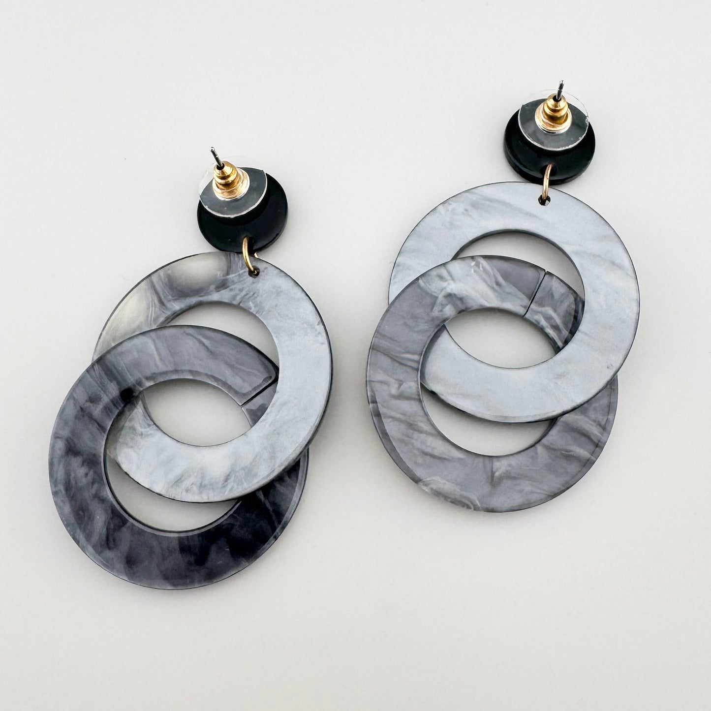 Earrings with two interlocking rings in a gray marble design.