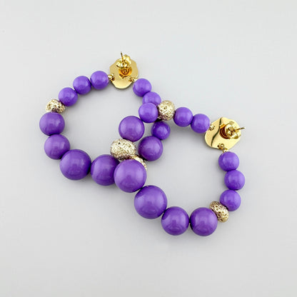 Elegant earrings with purple beads and gold details, by French brand Ikita.