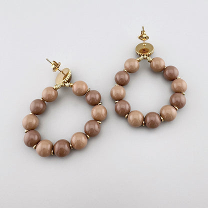 Earrings with large mocha-colored beads, by French brand Ikita.