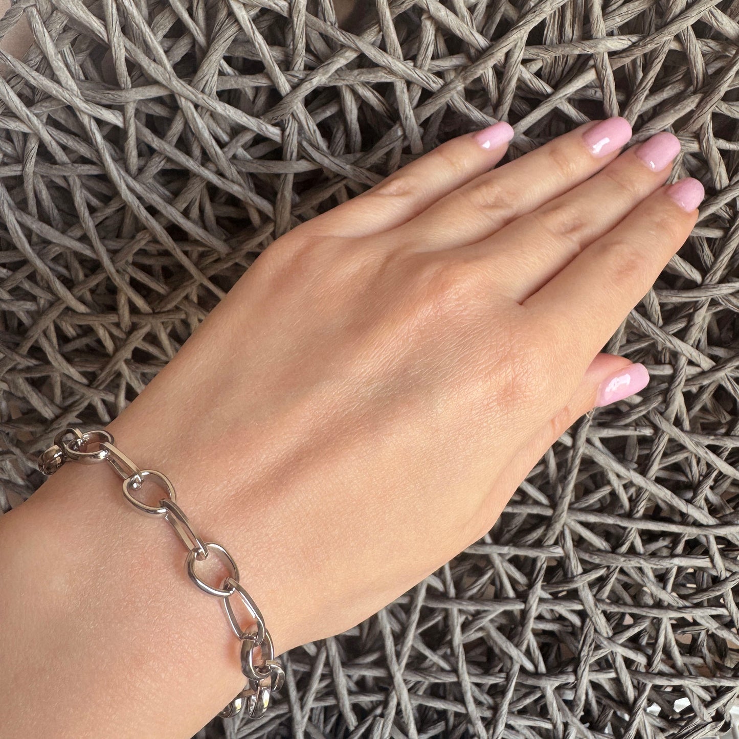 Stainless steel bracelet with modern interlocking links and a round toggle clasp, French brand Ikita.