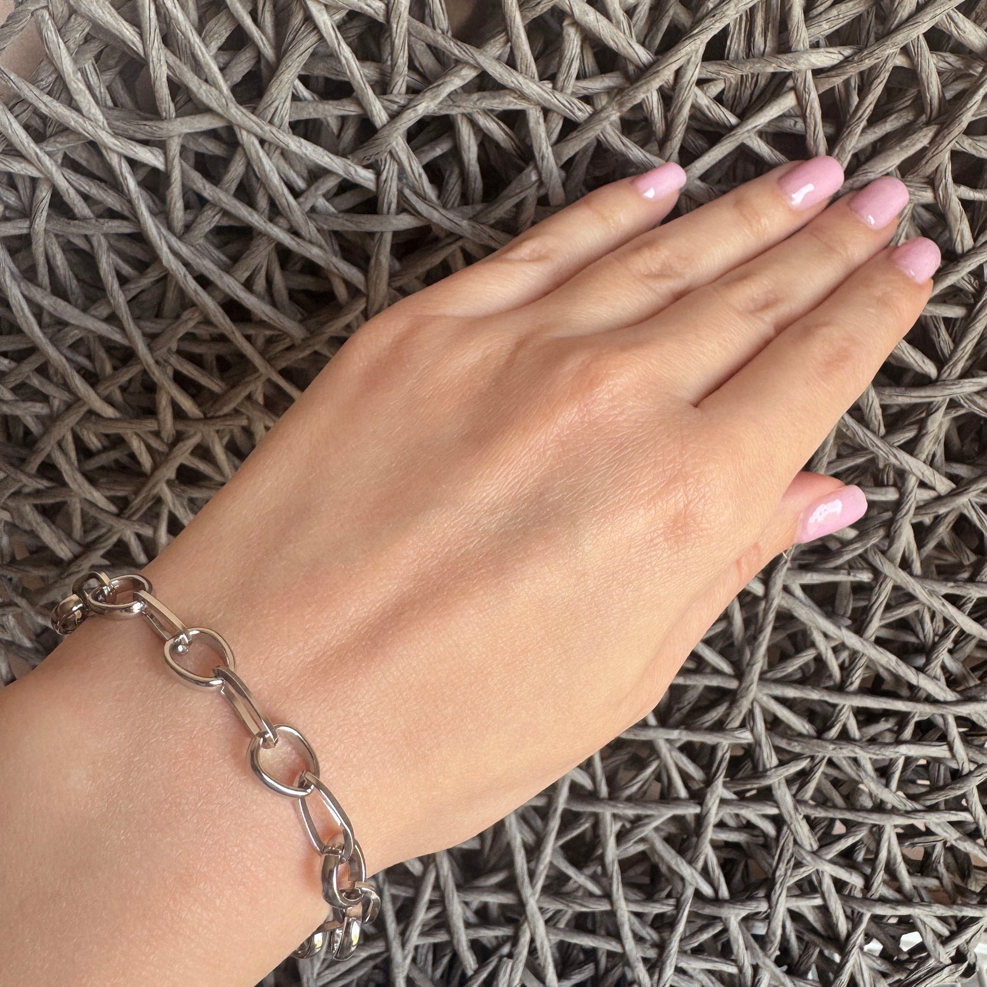 Stainless steel bracelet with modern interlocking links and a round toggle clasp, French brand Ikita.