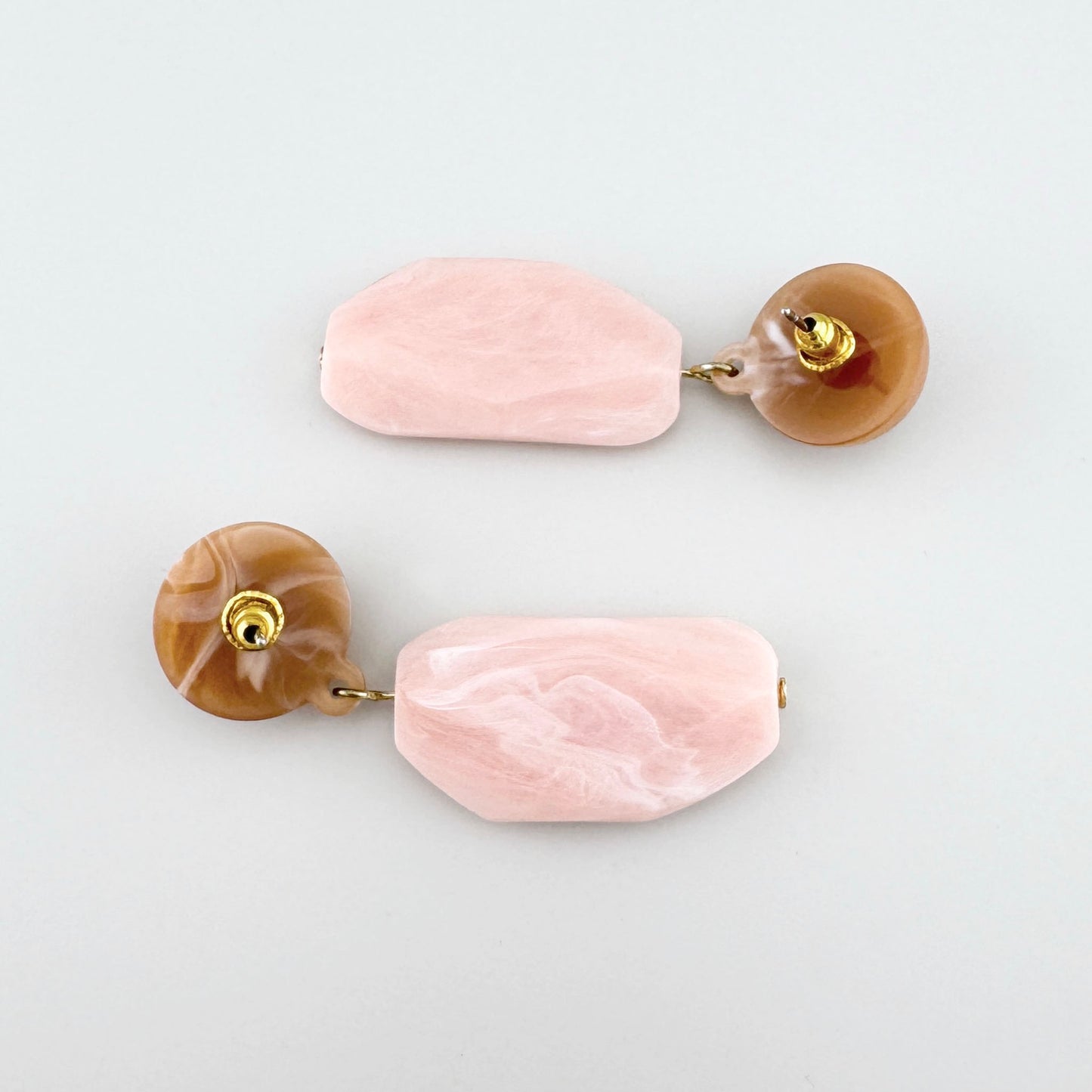 Earrings with pink stones and round brown accents.