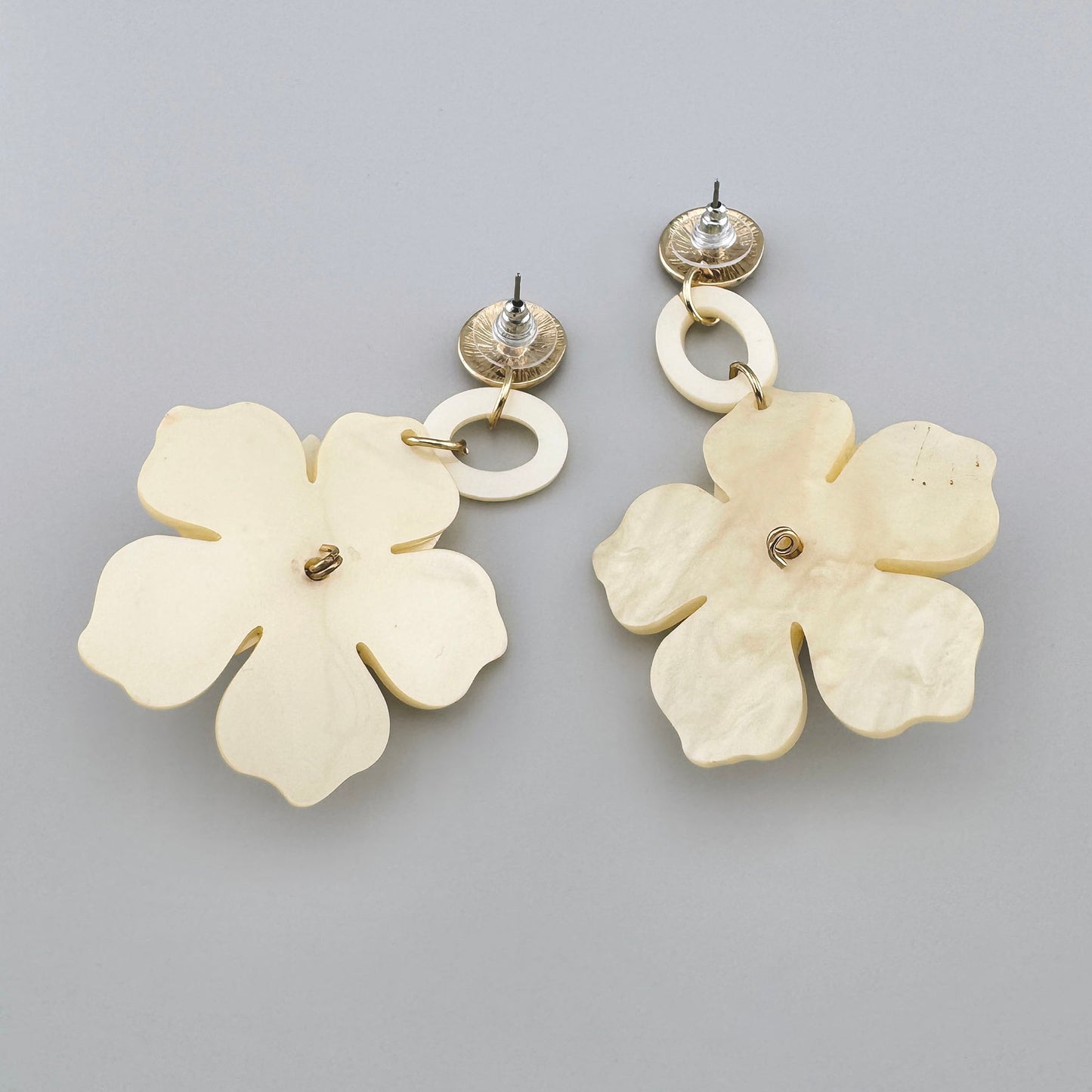 Cream flower earrings adorned with amber-colored crystals and gold-tone details.