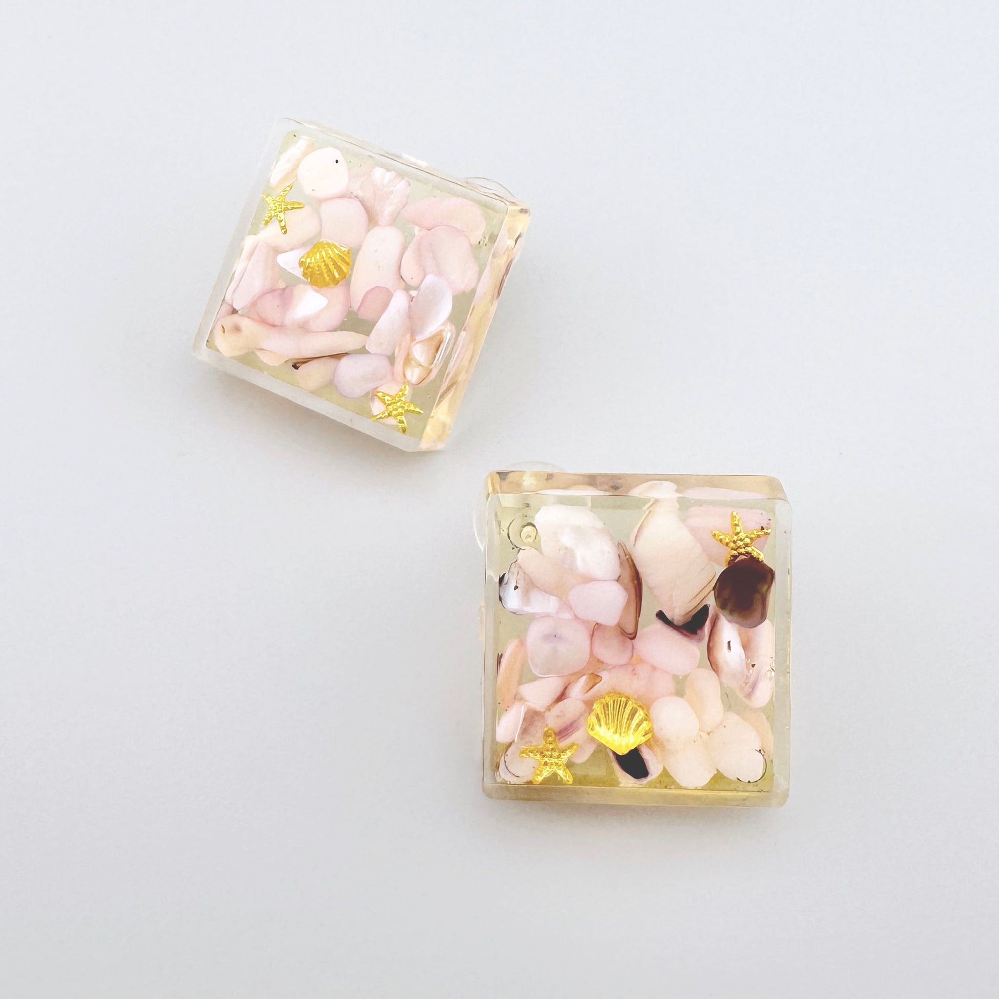 Square-shaped earrings filled with pastel-colored stones.