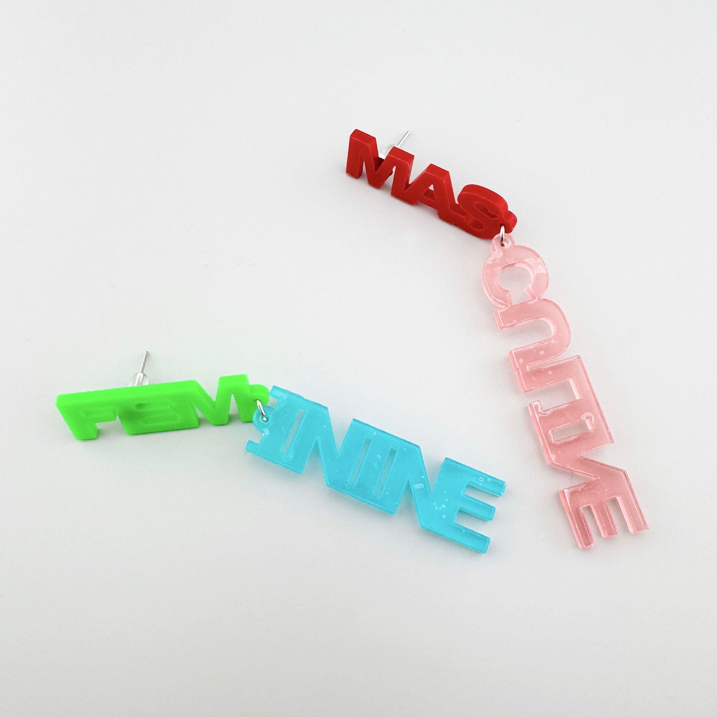 Bold earrings with 'FEM' and 'MAS' text in green, blue, and red colors.