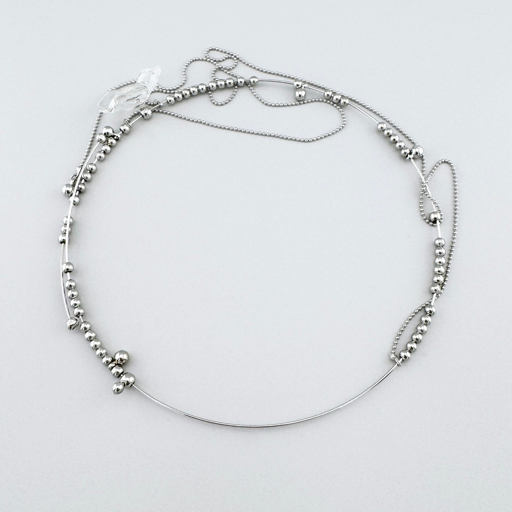 Halskette mit Metallperlen und einem transparenten Anhänger in Blumenform, spanische Marke Maravillas.
