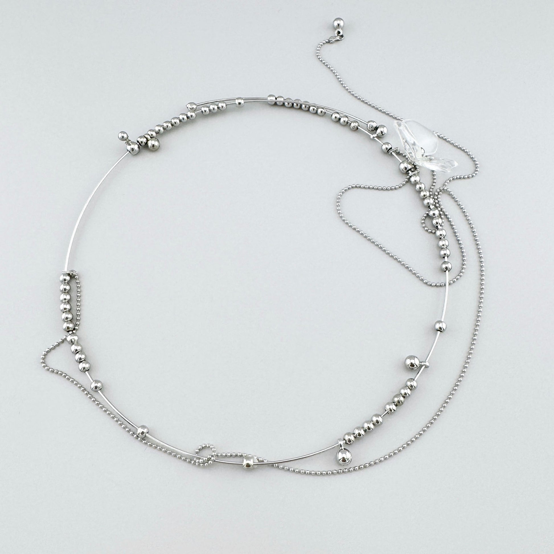 Collar con cuentas metálicas y colgante transparente en forma de flor, marca española Maravillas.