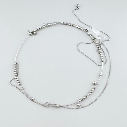 Collar con cuentas metálicas y colgante transparente en forma de flor, marca española Maravillas.