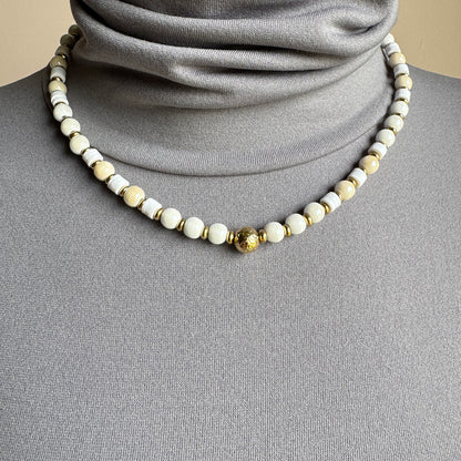 Necklace with round white and ecru ceramic beads and golden accents, French brand Ikita.