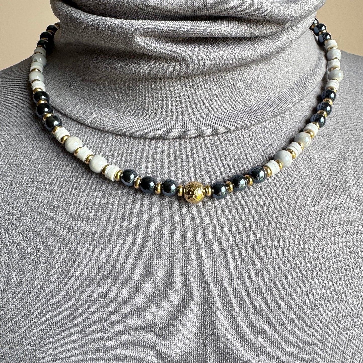 Necklace with ceramic beads in white and graphite tones and gold-plated accents, French brand Ikita.