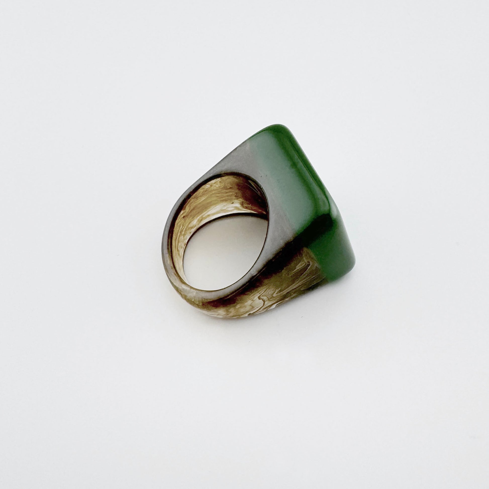 Anillo de plástico en verde con patrón marmoleado marrón, marca española Sonata.