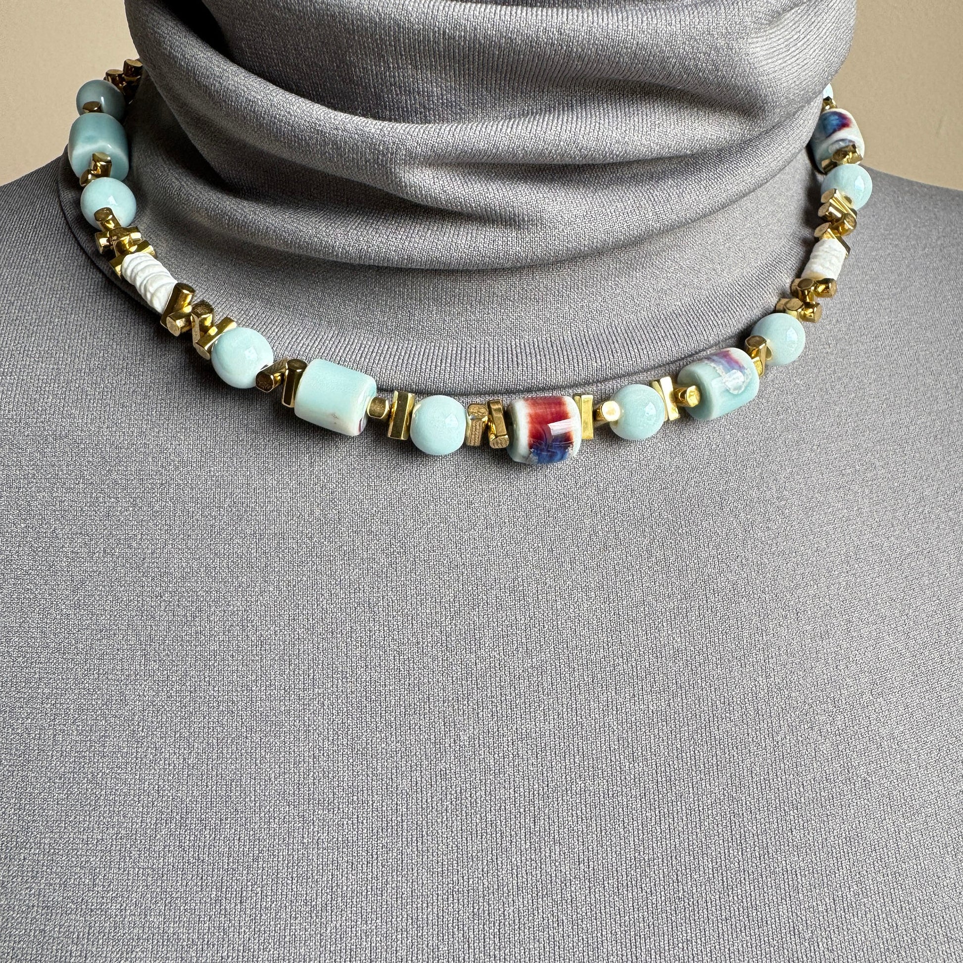 Necklace with blue ceramic beads, white discs, and gold spacers, French brand Ikita.