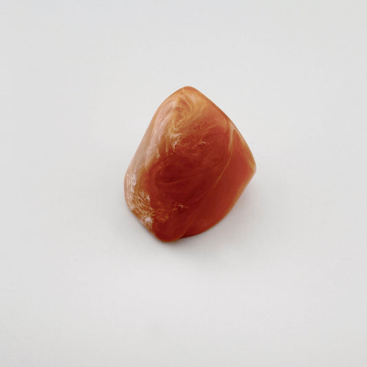 Terracotta-colored plastic ring with a marble-inspired pattern.