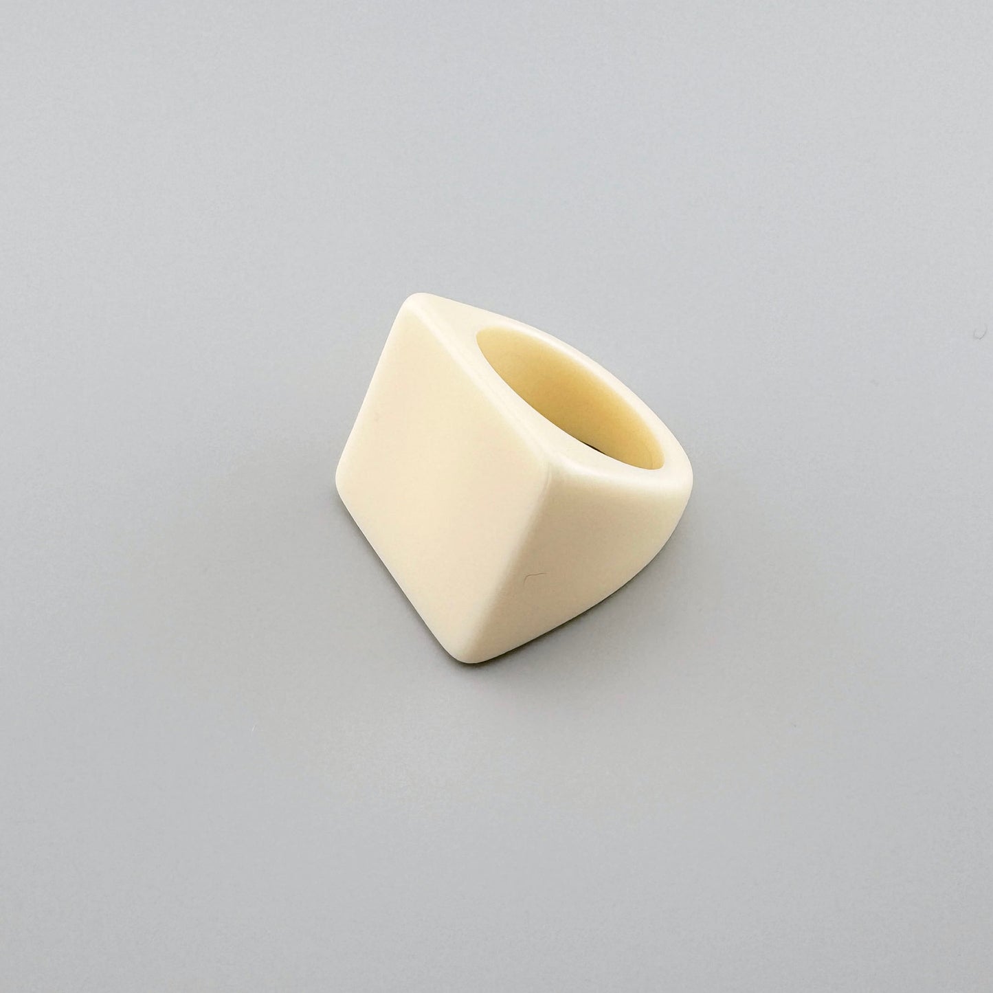 Geometrischer Ring in Cremefarbe mit modernem Design.