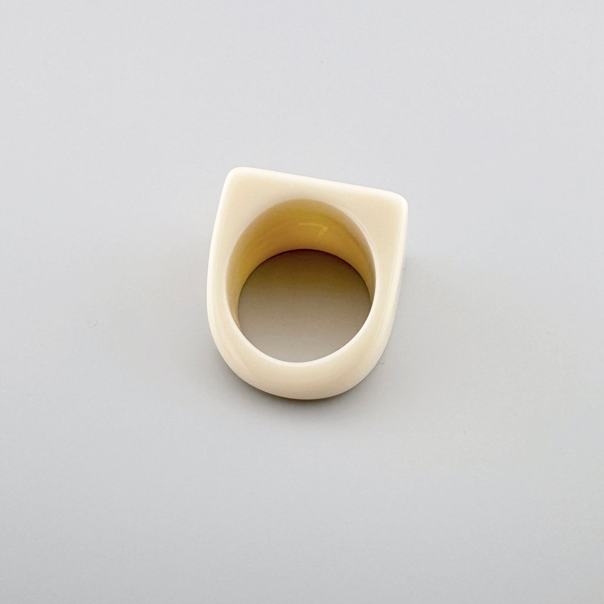 Bague géométrique de couleur crème au design moderne.