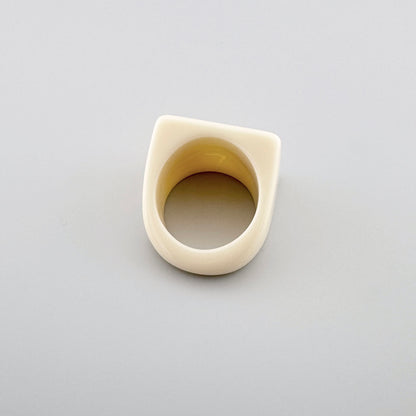 Bague géométrique de couleur crème au design moderne.