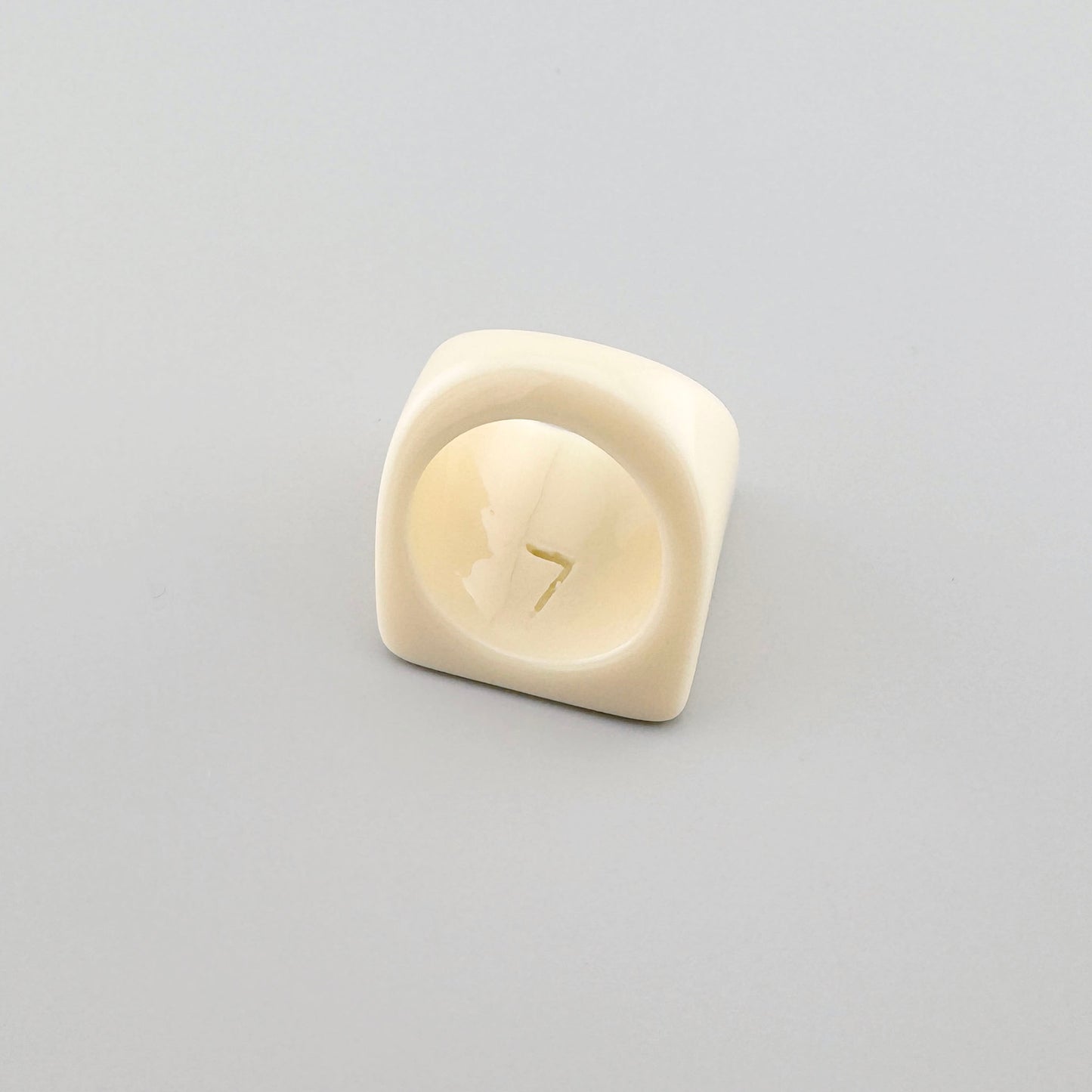 Geometric ring in a cream color with a modern design.