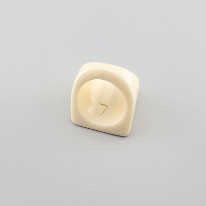 Geometric ring in a cream color with a modern design.