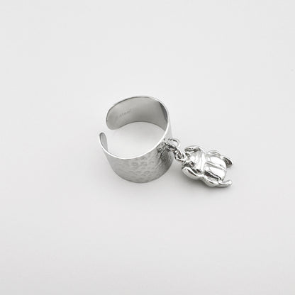 Silver-tone ring with a hammered texture and a scarab-shaped pendant.