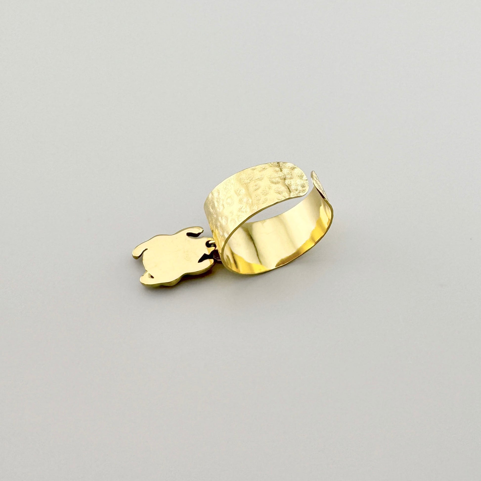 Anillo dorado con colgante en forma de escarabajo.