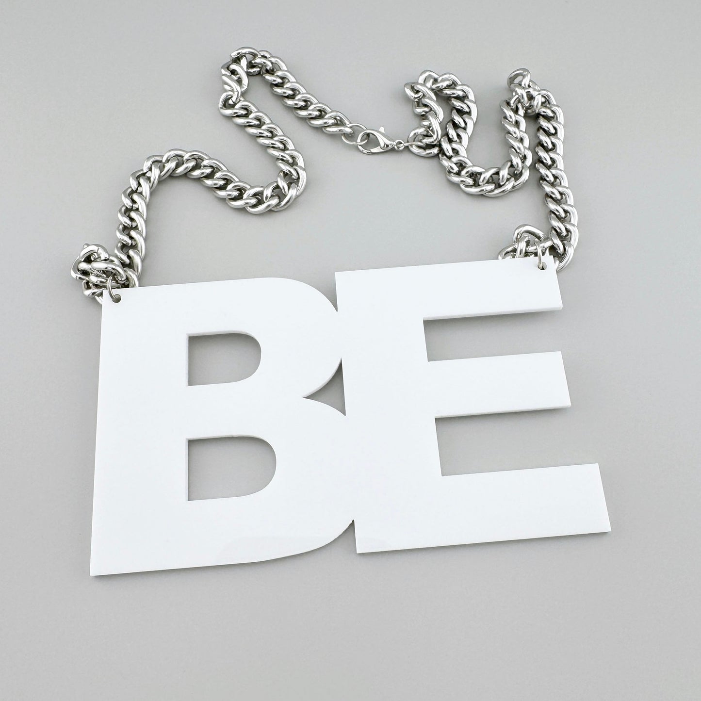 Set of two necklaces with white pendants “ART” and “BE” on chunky chains.