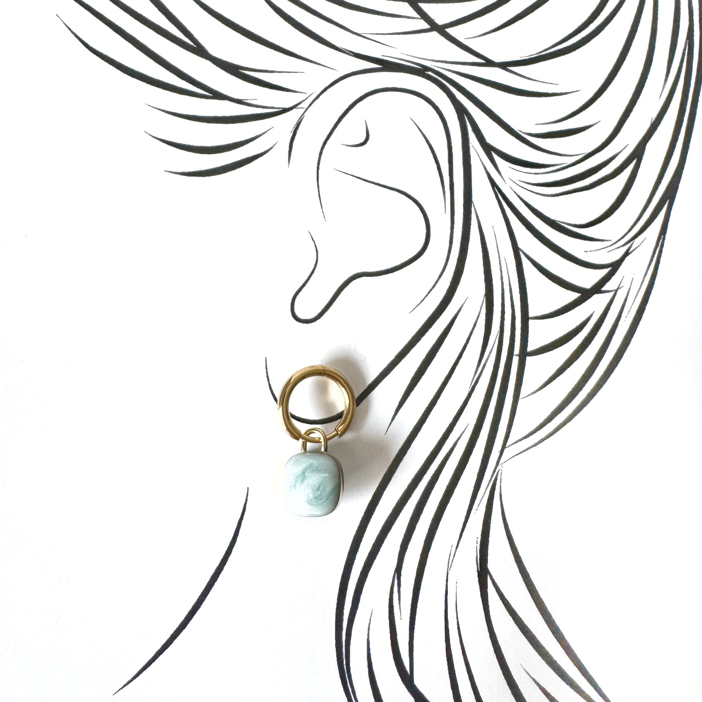 Gold hoop earrings with light blue marble-effect charms, French brand Cannelle.