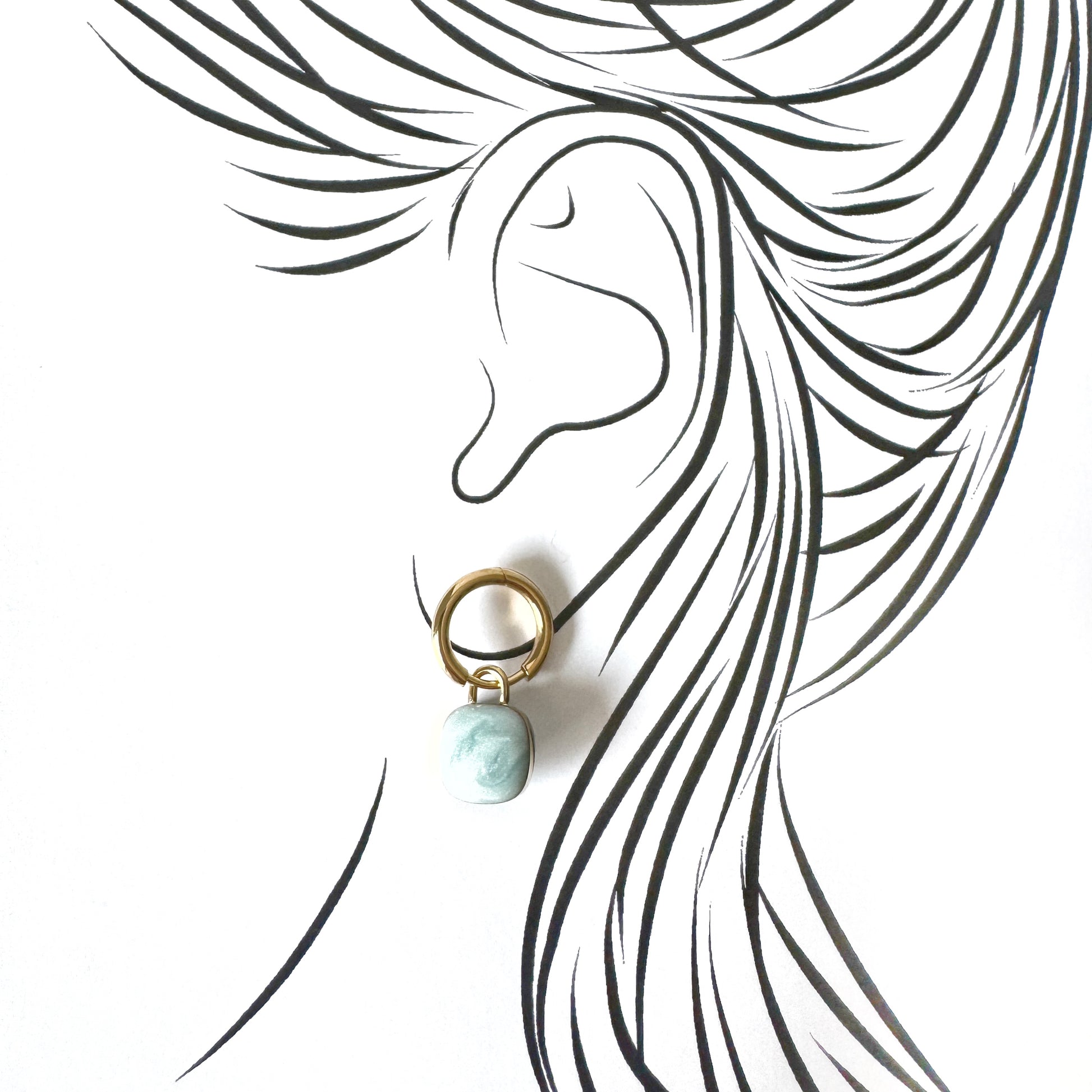 Gold hoop earrings with light blue marble-effect charms, French brand Cannelle.