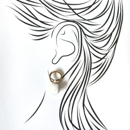 Gold hoop earrings with alabaster white porcelain charms, French brand Cannelle.