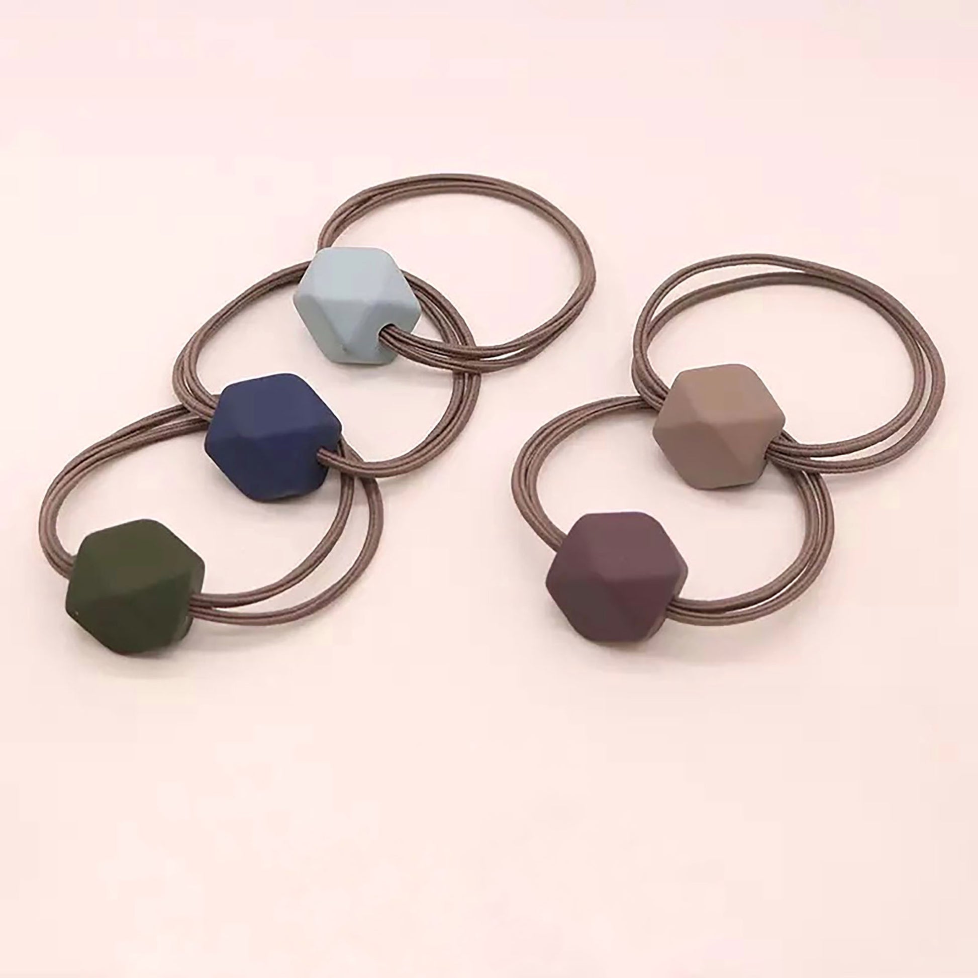 Hair tie in taupe shade with a matte hexagonal-shaped ornament.