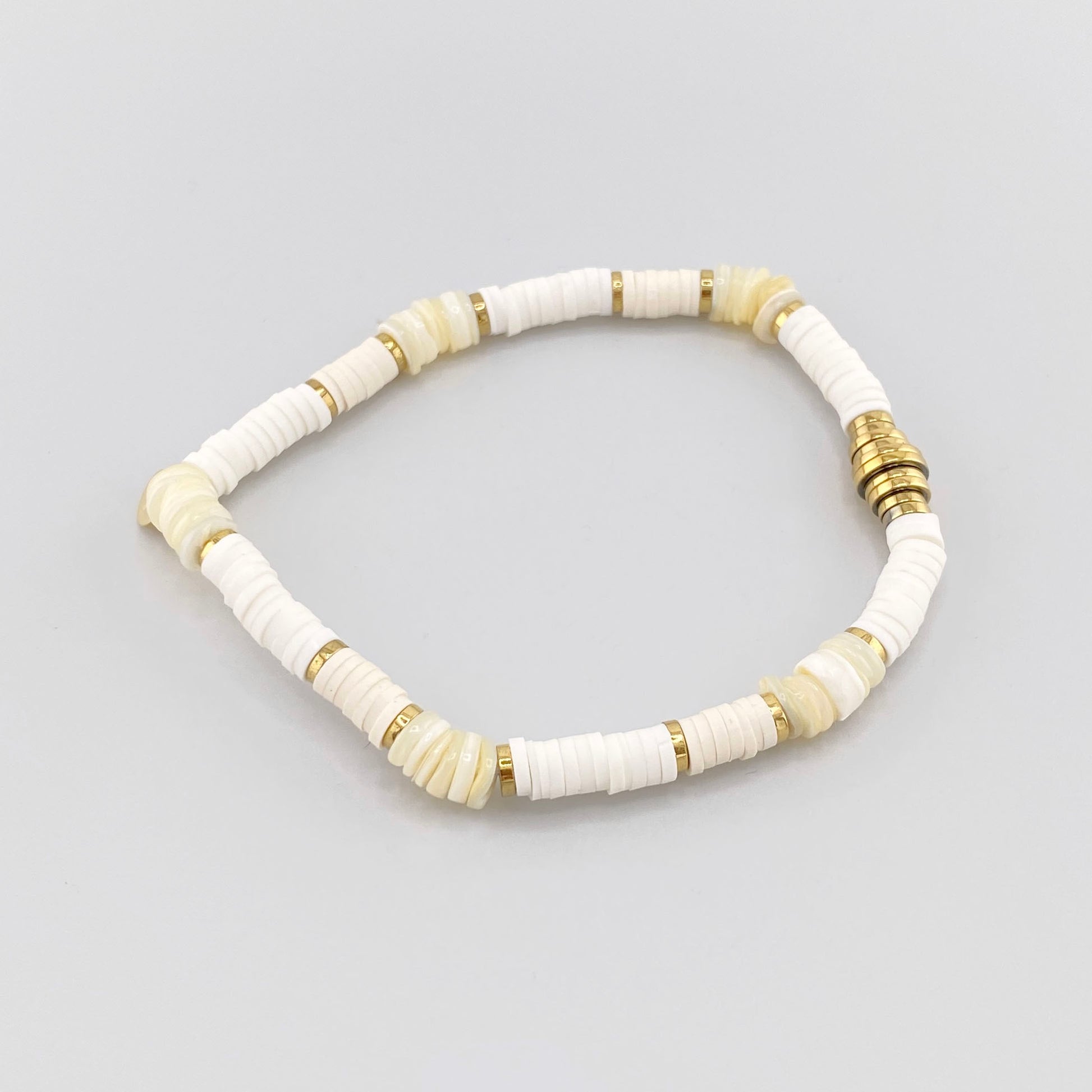 Pulsera elástica con cuentas blancas y detalles dorados, marca francesa IRL.