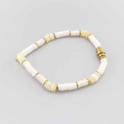Pulsera elástica con cuentas blancas y detalles dorados, marca francesa IRL.