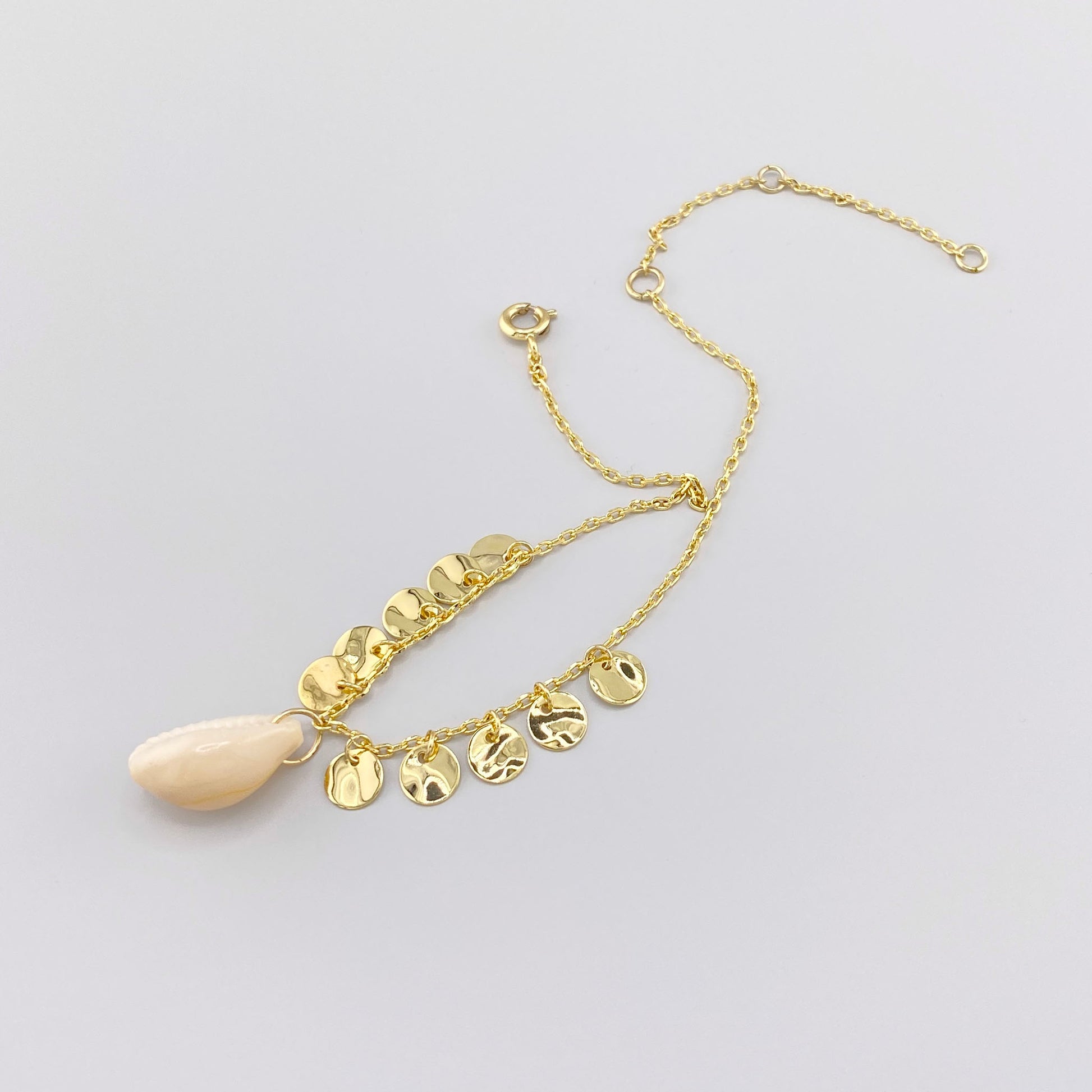 Anklet with natural shell and textured golden charms, French brand IRL.