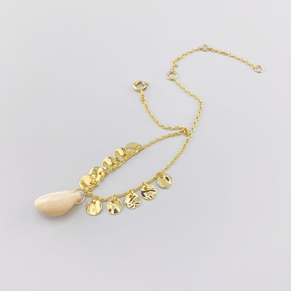 Anklet with natural shell and textured golden charms, French brand IRL.