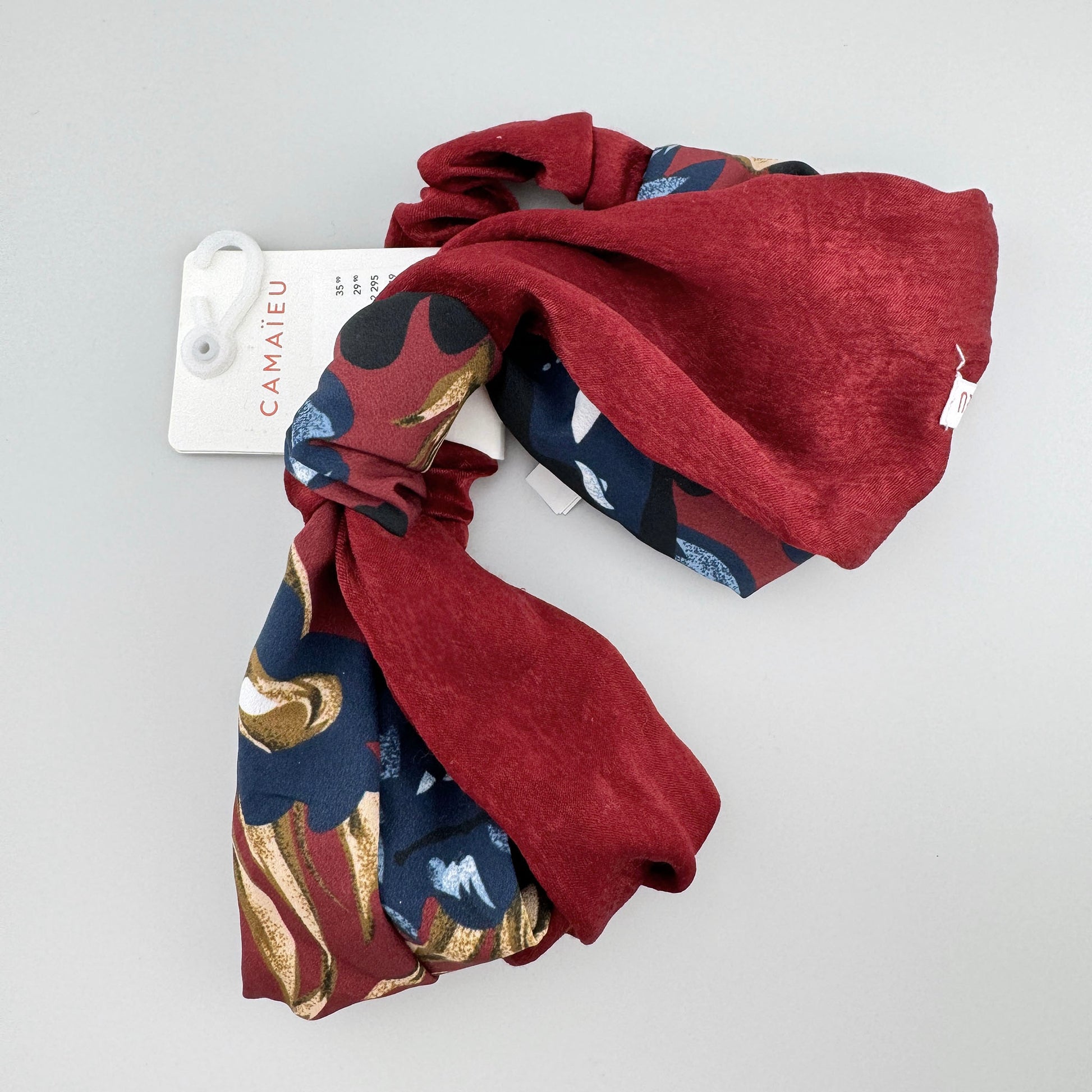 Headband made of red fabric with a floral insert, French brand Camaïeu.