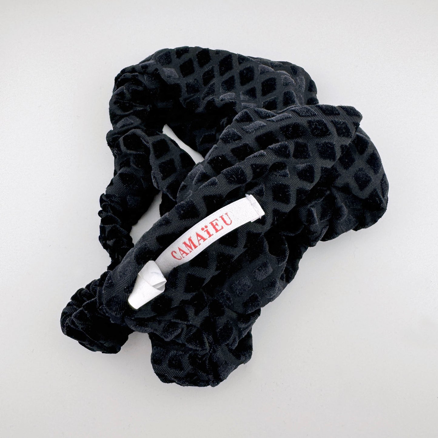 Headband made of black fabric with a velvet texture and geometric pattern, French brand Camaïeu.