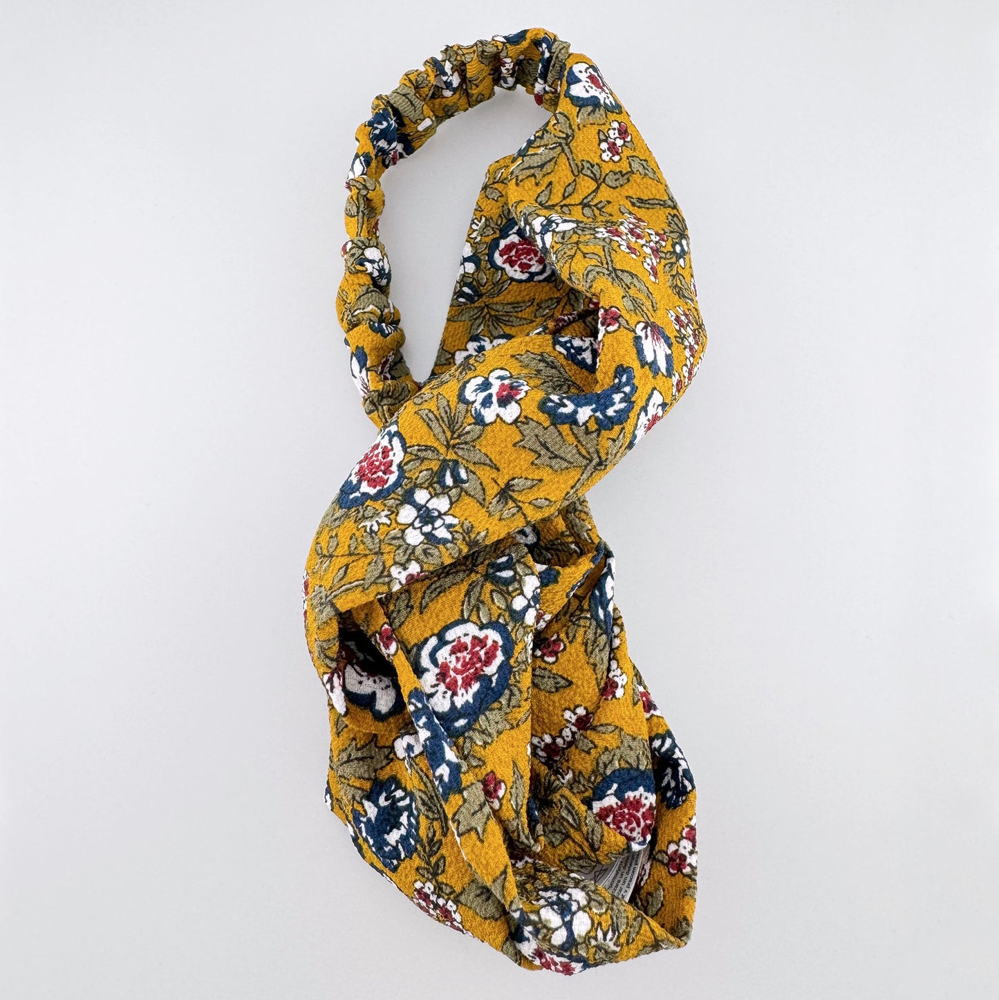 Trendy headband in mustard color with floral pattern, French brand Camaïeu.