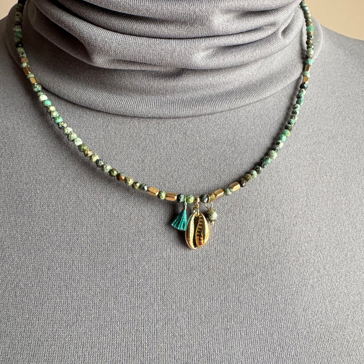 African turquoise necklace IRL worn close to the neck with faceted stones and a gold shell charm