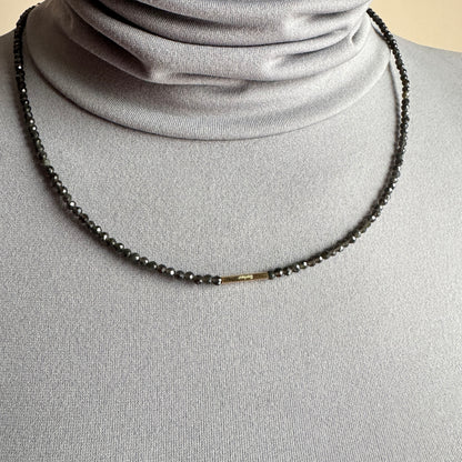 Agate necklace IRL worn close to the neck with dark faceted beads and gold accents
